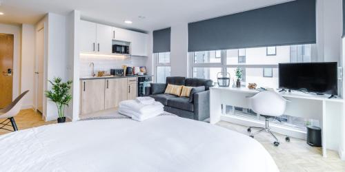 a bedroom with a white bed and a living room at City Studios, Preston in Preston