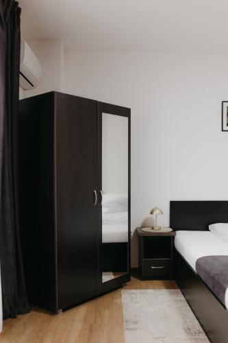 a bedroom with a black cabinet with a mirror at Pensiunea Pictorilor in Baia Mare