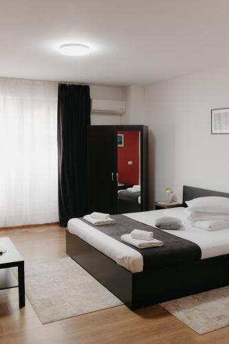 a bedroom with a large bed with towels on it at Pensiunea Pictorilor in Baia Mare