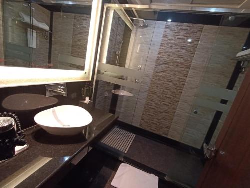 a bathroom with a shower with a sink and a toilet at Ramada by Wyndham Varanasi Katesar in Chandauli