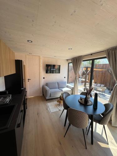 a kitchen and living room with a table and chairs at Exclusive Wellness House with Jacuzzi and Sauna, 10 Gardens in Privlaka