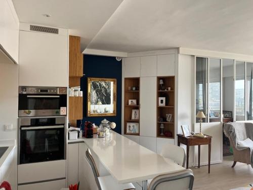 - une cuisine avec un comptoir blanc dans une pièce dans l'établissement 4-bed apartment PARIS 12, à Paris