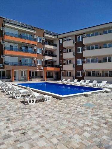 a swimming pool in front of a building at Apartman Sara S in Veliko Gradište