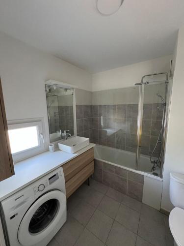 une salle de bain avec une machine à laver et un lavabo dans l'établissement Appartement T2 proche des calanques Sormiou et Morgiou, à Marseille