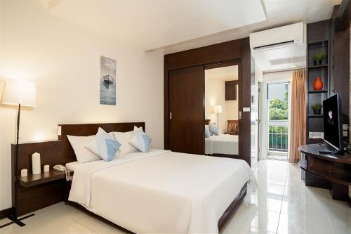 a bedroom with a large white bed and a television at Synsiri Ladprao 130 in Ban Bang Toei (1)