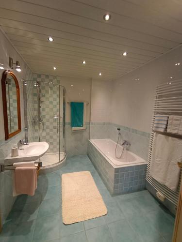 a bathroom with a tub and a sink and a bath tub at Ferienhaus - gemütlich und traditionell auf 90 m2 in Fürstenfeld