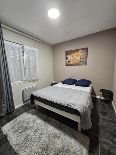 Un dormitorio con una cama grande con almohadas azules. en Gîte des Cyprès, en La Garde-Adhémar