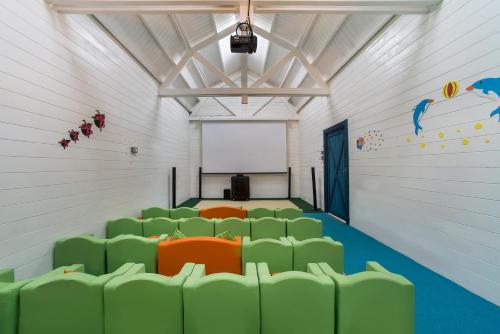 an empty room with green chairs and a white wall at Aska Lara Resort & Spa Hotel in Lara
