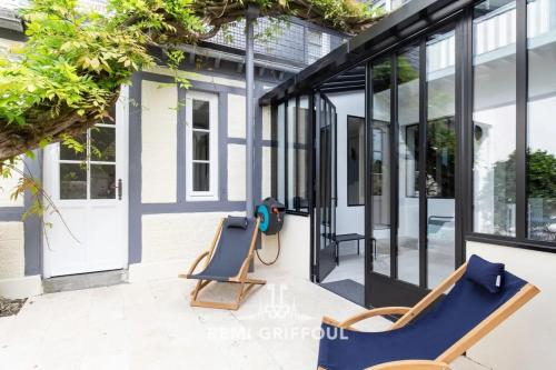 un patio con due sedie e porte a vetri di Villa Gernez Historic Center 10 guests a Honfleur