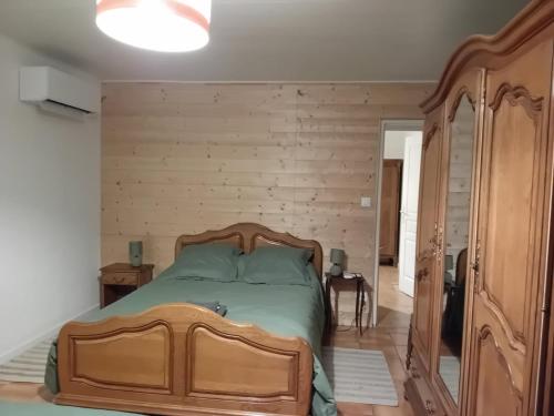 - une chambre avec un lit en bois et un mur en bois dans l'établissement Un air de campagne à Bourges, à Bourges