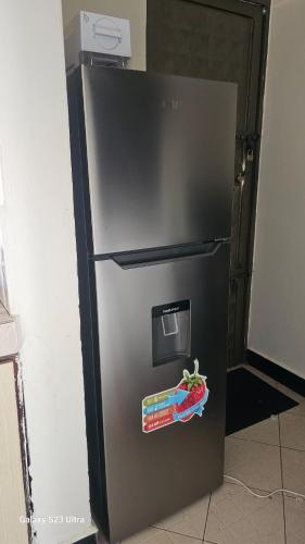 a stainless steel refrigerator with a sticker on it at The Rocky Apartment in Namulanda