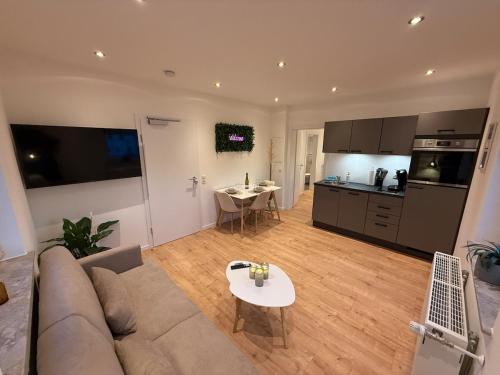 a living room with a couch and a table and a kitchen at NAVIA Sol - Premium Apartments Montabaur in Montabaur
