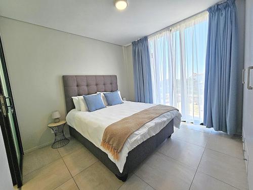 a bedroom with a bed and a large window at Bella Mare 12 on Second in Gqeberha