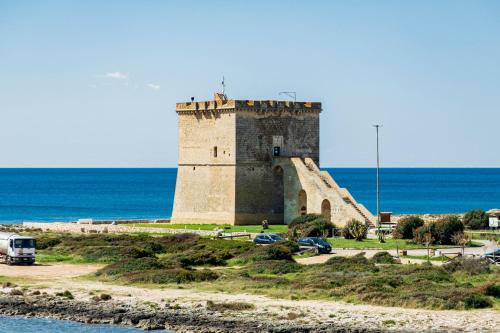 a castle on a hill next to the ocean at Hotel Alba in Torre Lapillo