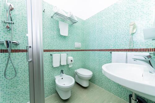 a bathroom with a toilet and a sink and a shower at Hotel Alba in Torre Lapillo