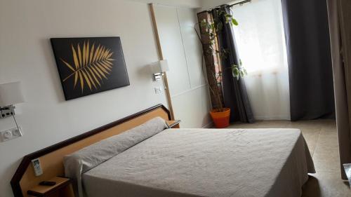 une chambre avec un lit et un tableau au mur dans l'établissement Appartement Porto - Ota, à Porto Ota