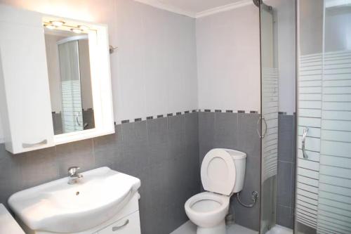 a bathroom with a toilet and a sink and a mirror at Laconian Blue Residence in Gythio