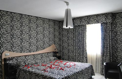 a bedroom with a bed and a black and white wallpaper at Hotel Del Sole in Pastorano