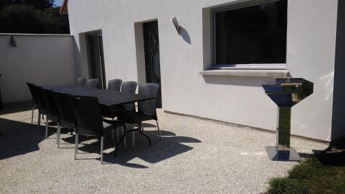 a black table and chairs in front of a building at les gîtes de la cuesta in Henneveux