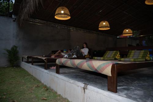 two beds on a wall with a woman sitting on them at River Nest Hostel in Kampot