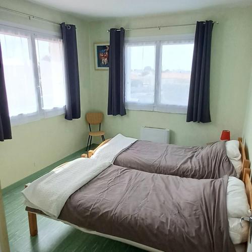 - un lit dans une chambre avec 2 fenêtres dans l'établissement Villabellevue, à La Faute-sur-Mer