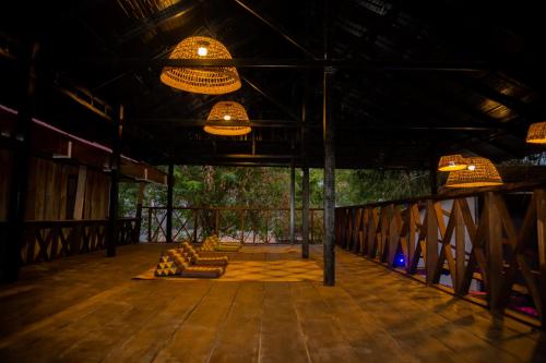 a room with a wooden floor and chandeliers at River Nest Hostel in Kampot