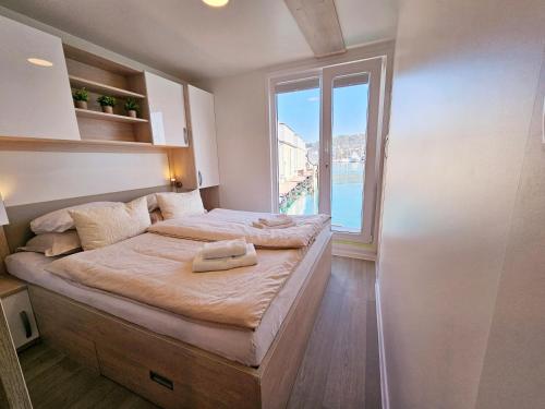 a bedroom with a large bed with a large window at Sea Diva - luxury boathouse in Portorož