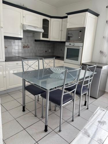 - une cuisine avec une table en verre et des chaises dans l'établissement CHARMANT T3 Pietralba, à Ajaccio