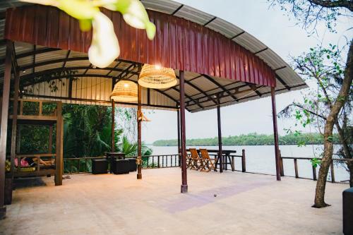 a pavilion with a view of a body of water at River Nest Hostel in Kampot