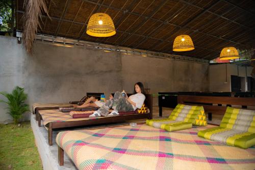 two people are sitting on beds in a room at River Nest Hostel in Kampot