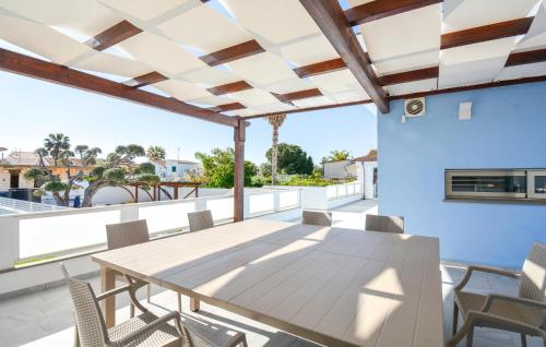 ein Esszimmer mit Tisch und Stühlen auf einem Balkon in der Unterkunft 4 Bedroom Amazing Home In Kaukana in Villaggio Azzurro