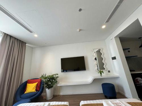 a room with two chairs and a tv on a wall at Flamingo1 Ibiza Hai Tien in Nam Khê