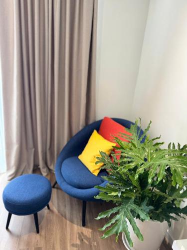 a blue chair with colorful pillows and a plant at Flamingo1 Ibiza Hai Tien in Nam Khê