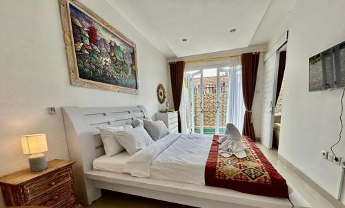 a bedroom with a large white bed and a window at Villa VELIA private pool in Badung