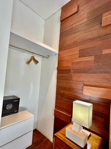 a room with a wooden accent wall and a desk with a lamp at Villa VELIA private pool in Badung