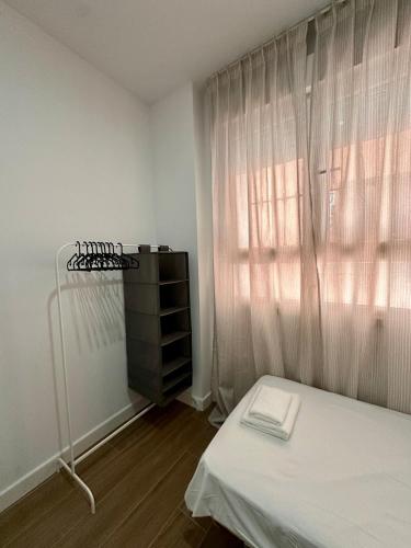Un dormitorio pequeño con una cama y una ventana. en Stay in Triana, en Sevilla