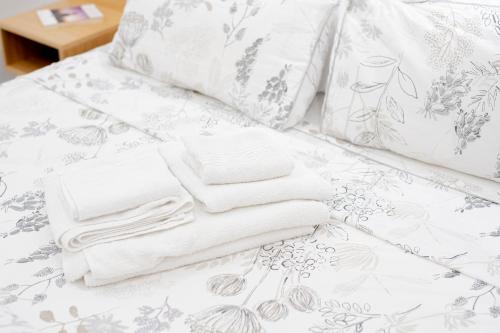 a pile of towels sitting on top of a bed at Eos - Elegants Apartments & Suites in Siracusa