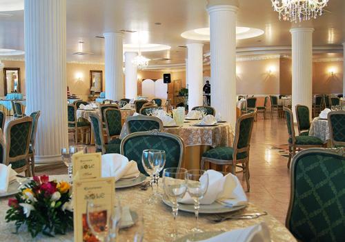 uma sala de jantar com mesas e cadeiras e um lustre em Hotel Del Sole em Pastorano
