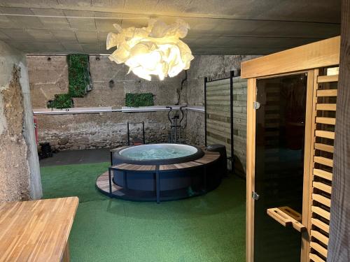 a room with a tub in the middle of a room at Le vermeil - demeure de charme avec spa - Borne de recharge électrique in Nivolas-Vermelle