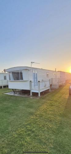 a mobile home parked in a field with the ocean at Y29 golden anchor in Chapel Saint Leonards