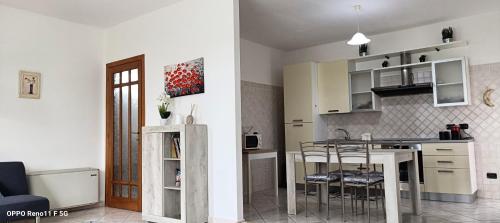 a kitchen with a table and chairs in a room at Casa DàCà in Marrùbiu