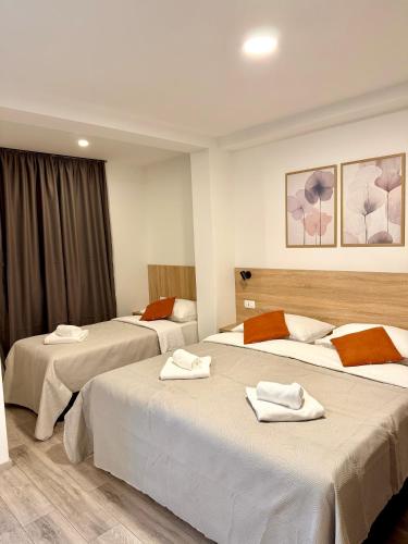 a hotel room with two beds with towels on them at Cloud9 Airport Rooms in Močići