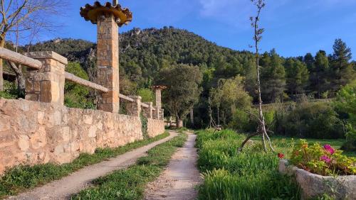 un camino de tierra junto a una pared de piedra en La Calma Montblanc Prenafeta, en Prenafeta