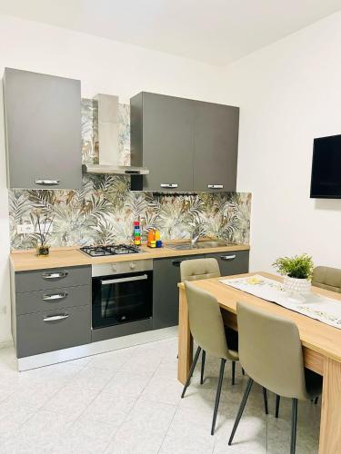 a kitchen with a table and a stove and cabinets at GioGio house in Vico Equense