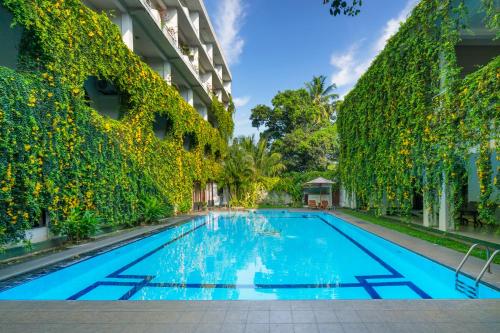 a swimming pool in front of a building at Kandyan Reach Hotel in Kurunegala