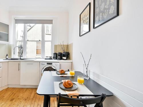 a kitchen with a table with two plates of food on it at Huge 2 Bedrooms 3 Beds! Covent GDN 3 min to subway in London