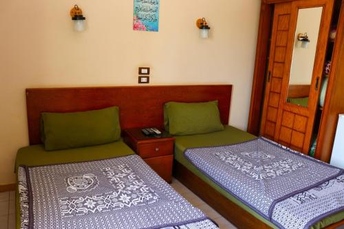 two beds sitting next to each other in a room at بيت الشباب الاسماعيلية in Ismailia