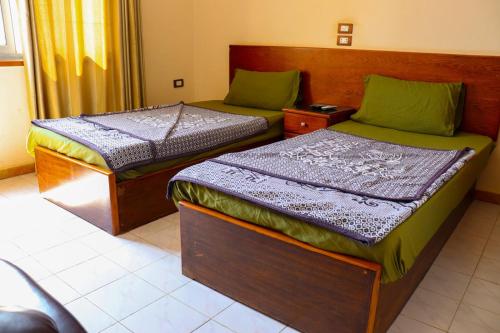two twin beds in a room with at بيت الشباب الاسماعيلية in Ismailia
