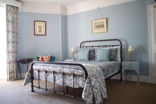 Un dormitorio con una cama con paredes azules. en Woodlands, Teignmouth, en Teignmouth