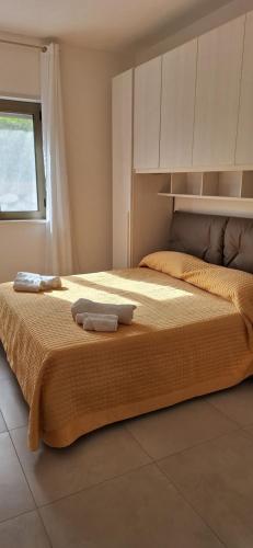 a bedroom with a bed with two towels on it at Appartamento Miele in Zambrone